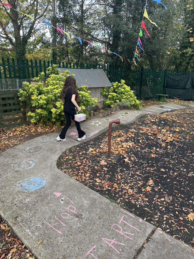 Child walking along a garden path decorated with chalk drawings